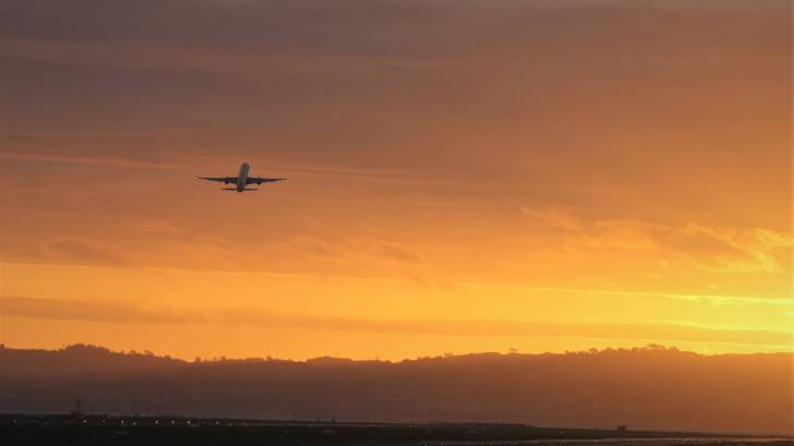 plane taking off in the sun set