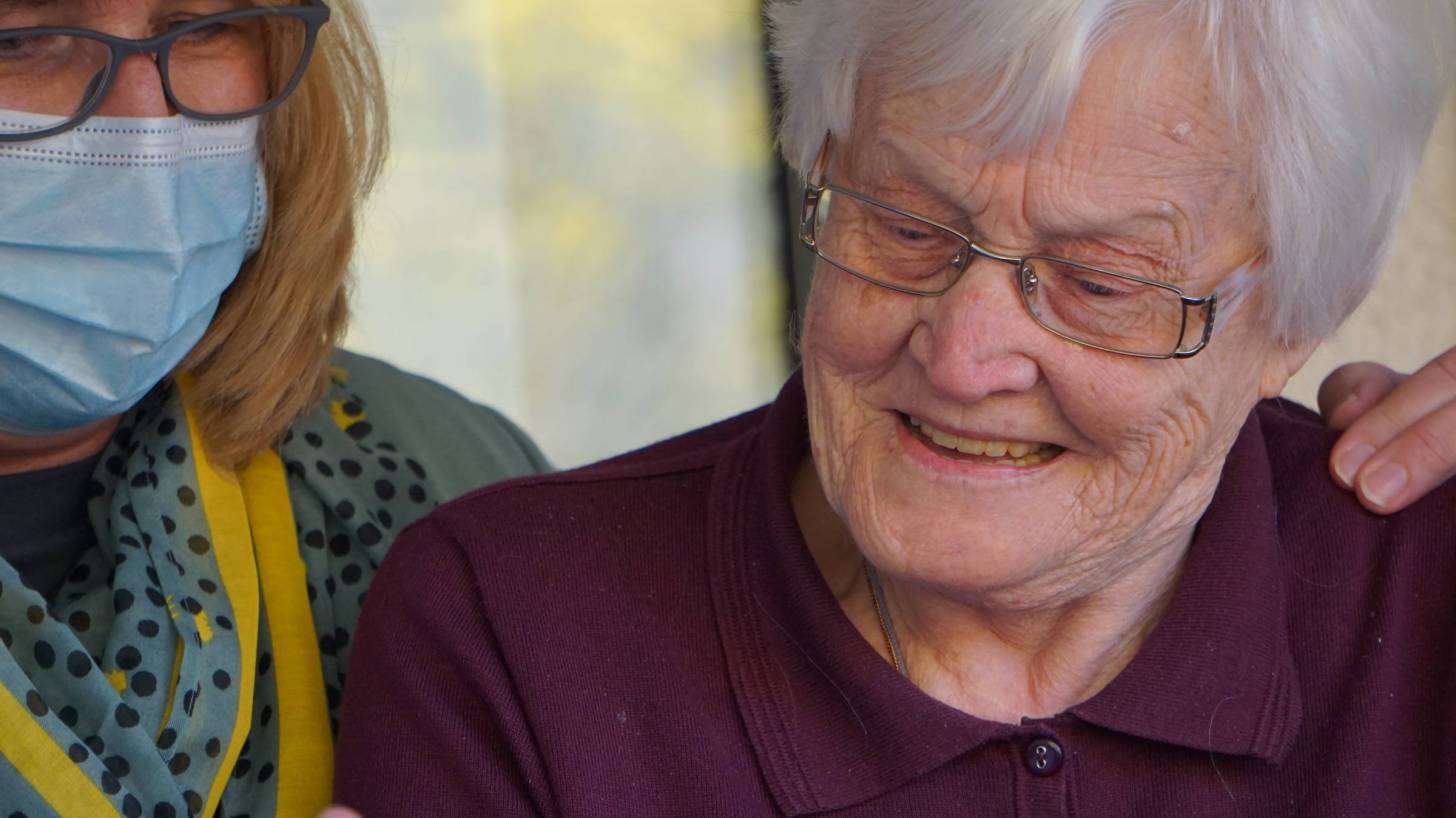 health care worker look at test results with a resident of the nursing home