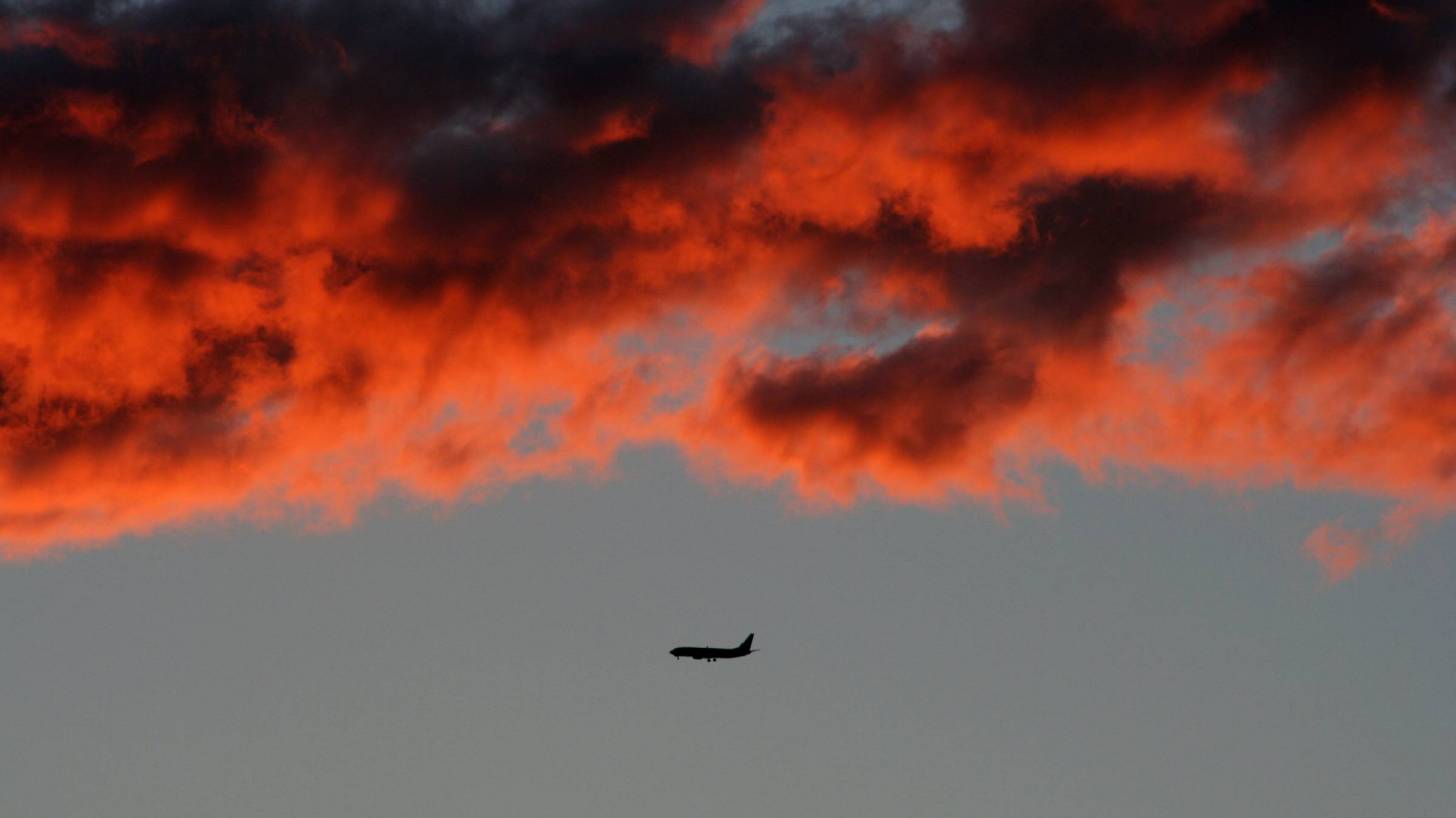 plane flying in the red sky