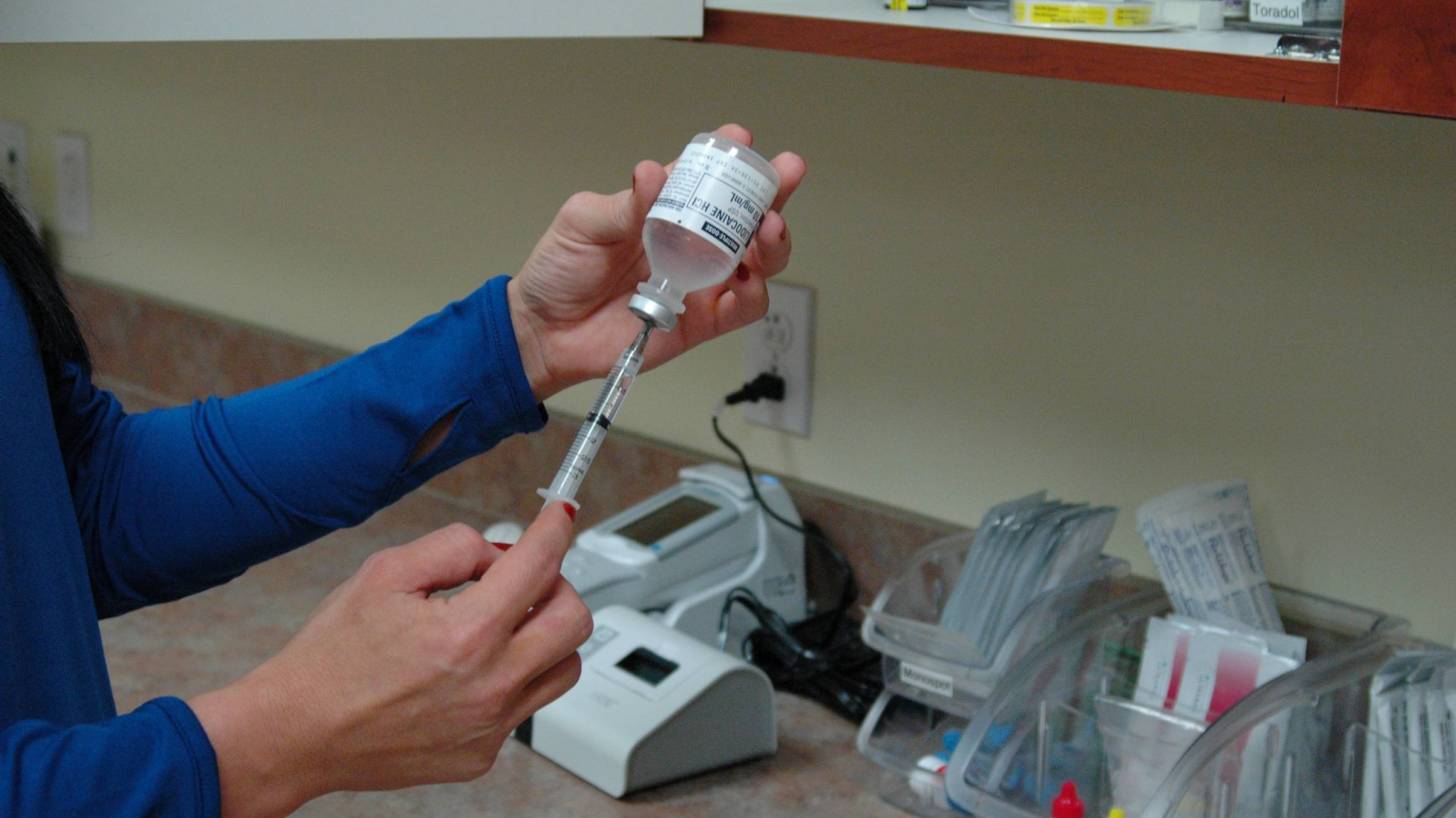 nurse filling a syringe for a flu shot