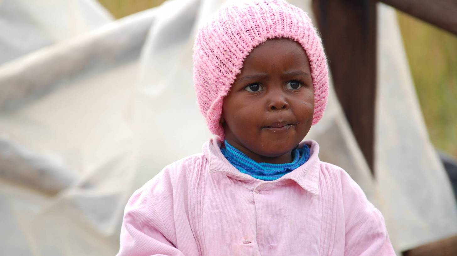 young african girl with pink coat and hat