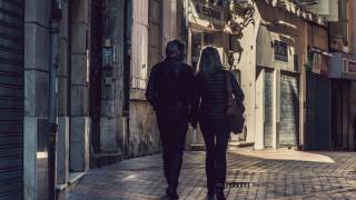 older couple walking thru an old town in europe