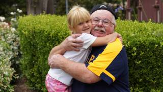 happy healthy grandpa hugging his grand daughter