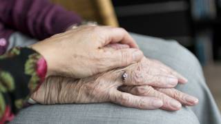 care giving holding PD patient hands